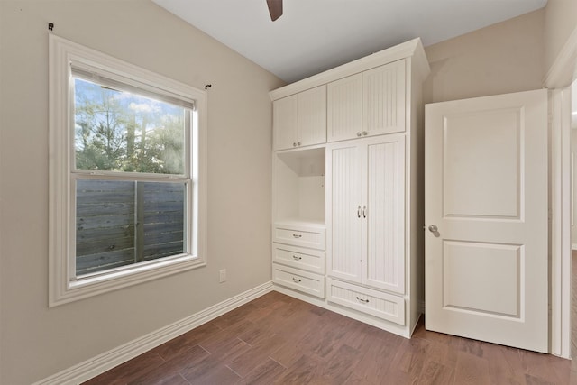 unfurnished bedroom featuring ceiling fan and dark wood-type flooring