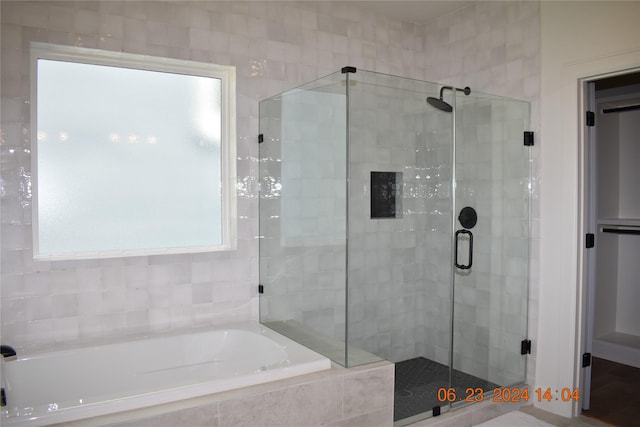 bathroom featuring shower with separate bathtub