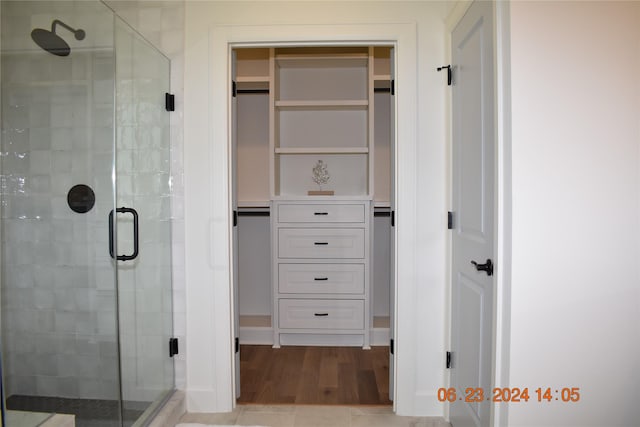 bathroom with hardwood / wood-style floors and a shower with door