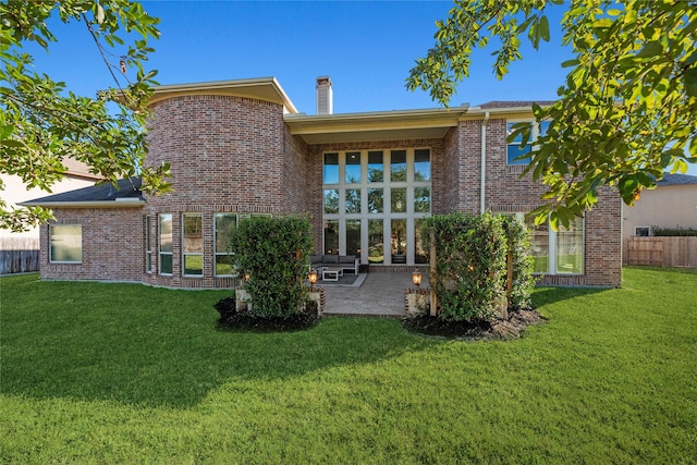 rear view of house featuring a yard and a patio