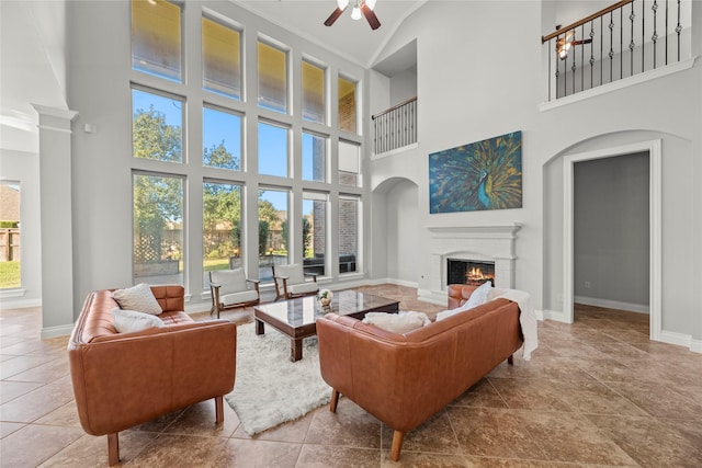 living room featuring a towering ceiling, tile patterned floors, and ceiling fan