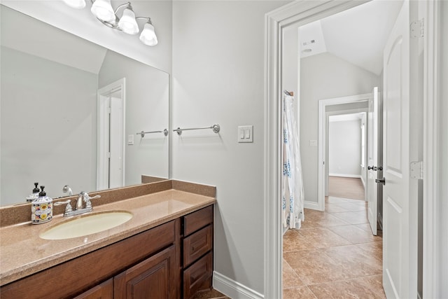 bathroom featuring tile patterned floors, vanity, and lofted ceiling