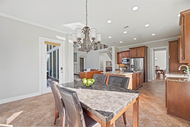 tiled dining room with sink, an inviting chandelier, and ornamental molding