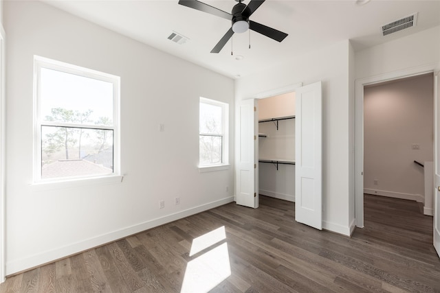 unfurnished bedroom with visible vents, baseboards, and dark wood-type flooring