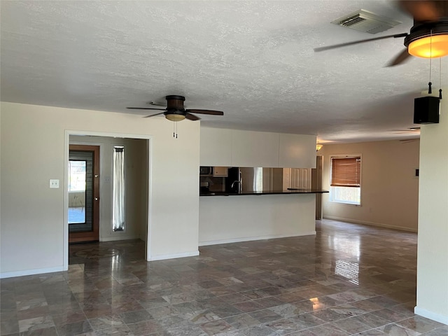 unfurnished room featuring ceiling fan and a textured ceiling