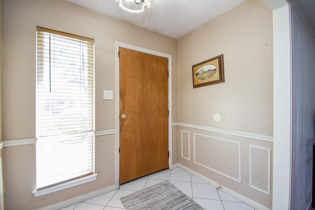 tiled foyer featuring a textured ceiling and a wealth of natural light