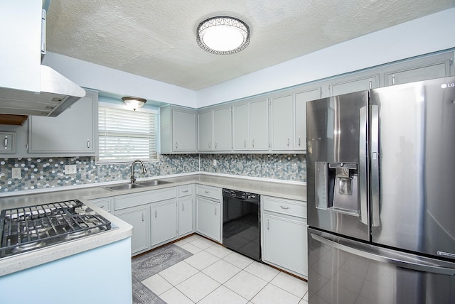 kitchen featuring stainless steel fridge, a textured ceiling, sink, light tile patterned floors, and black dishwasher