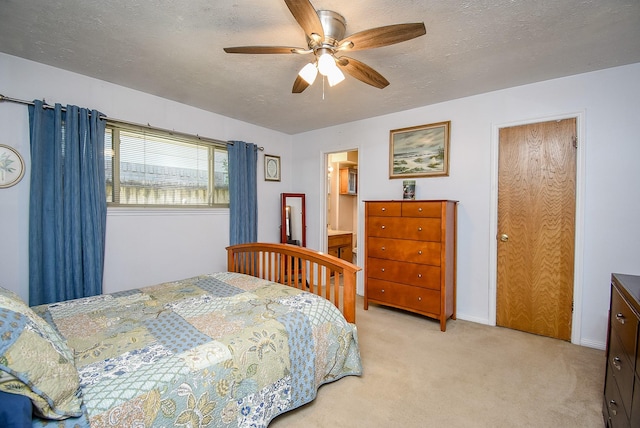 bedroom featuring ensuite bath, ceiling fan, light carpet, and a textured ceiling