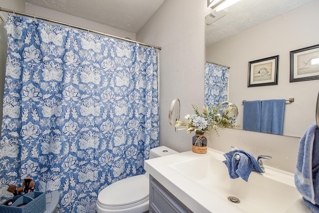 bathroom with vanity, a textured ceiling, and toilet