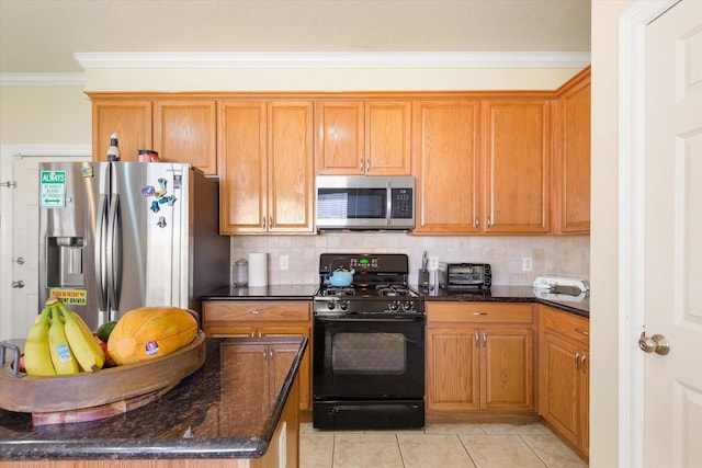 kitchen with dark stone countertops, ornamental molding, appliances with stainless steel finishes, tasteful backsplash, and light tile patterned flooring