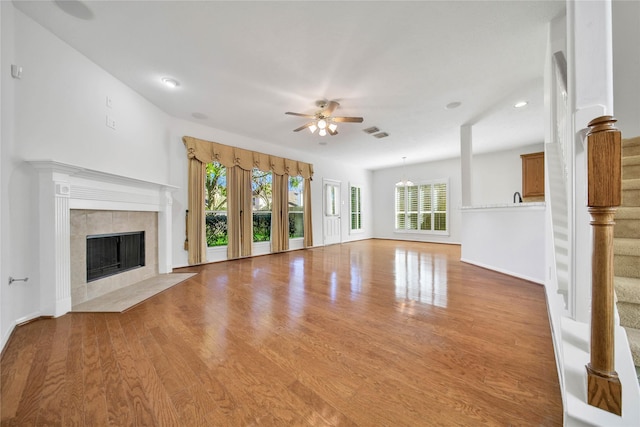 unfurnished living room featuring a fireplace, a wealth of natural light, and light hardwood / wood-style flooring