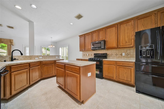 kitchen featuring black appliances, decorative light fixtures, tile countertops, a chandelier, and a center island