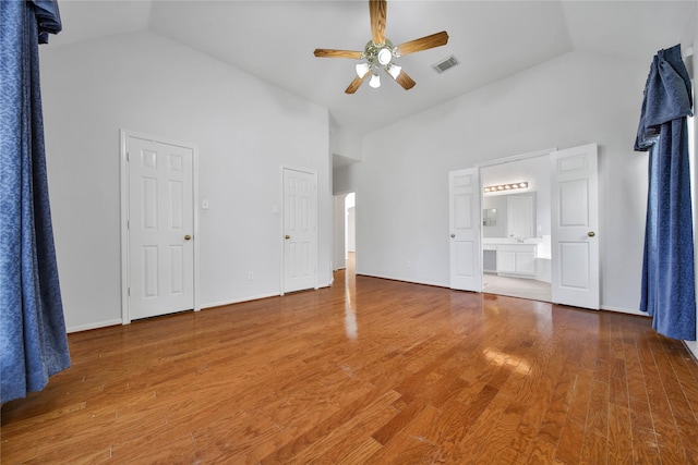 unfurnished living room with wood-type flooring, high vaulted ceiling, and ceiling fan