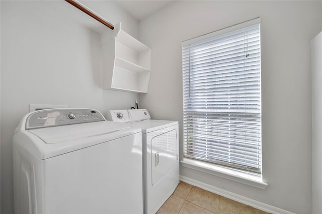 washroom featuring washing machine and dryer and light tile patterned floors