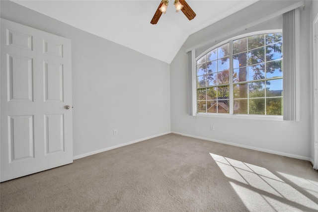 spare room featuring light carpet, ceiling fan, and lofted ceiling