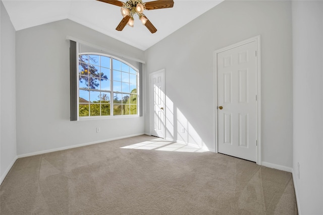 spare room with ceiling fan, light colored carpet, and lofted ceiling