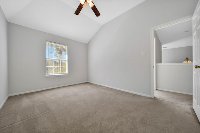 carpeted empty room with ceiling fan and vaulted ceiling