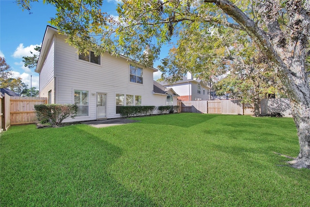 rear view of property featuring a lawn