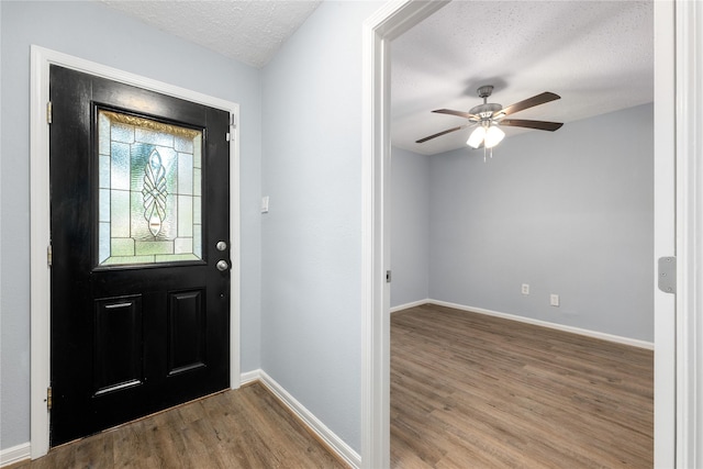 entrance foyer with hardwood / wood-style flooring, ceiling fan, and a textured ceiling