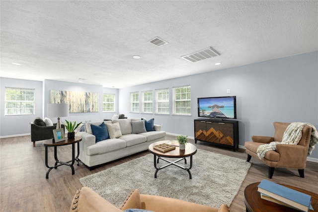 living room with a textured ceiling and light hardwood / wood-style floors