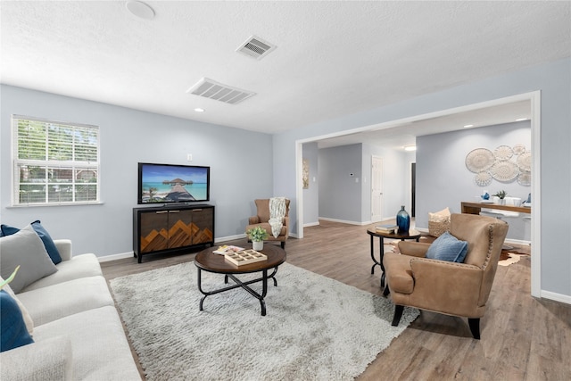 living room featuring a textured ceiling and light hardwood / wood-style flooring