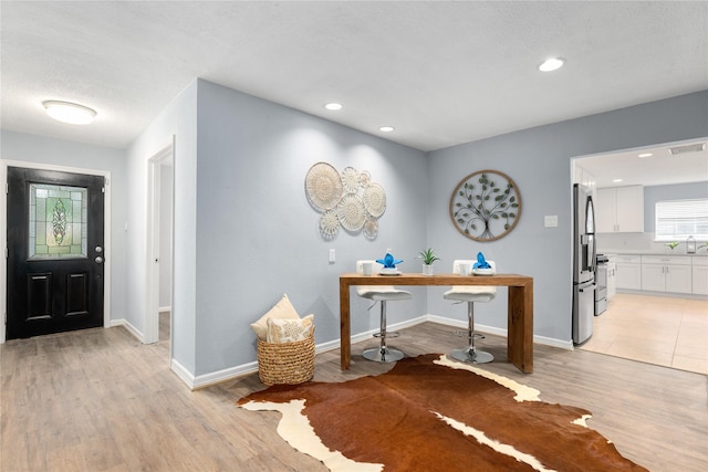 entryway with sink and light wood-type flooring