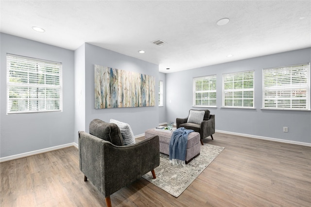 sitting room with hardwood / wood-style floors and a textured ceiling