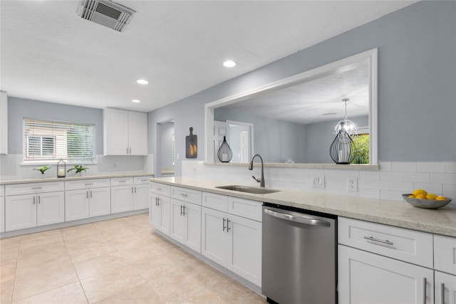 kitchen featuring dishwasher, backsplash, white cabinets, sink, and light tile patterned floors