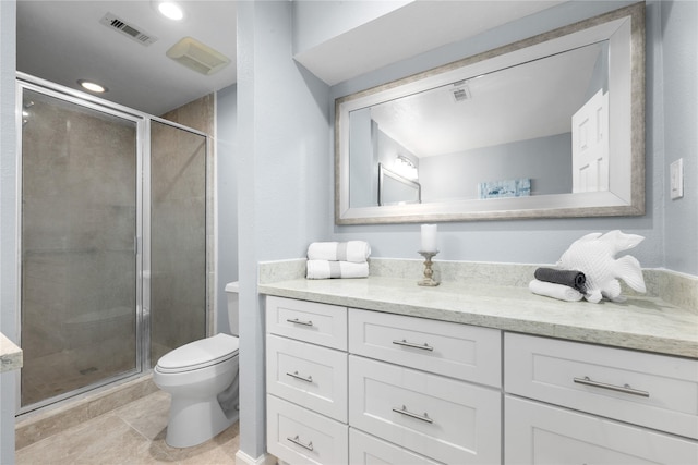 bathroom featuring tile patterned flooring, vanity, toilet, and a shower with shower door