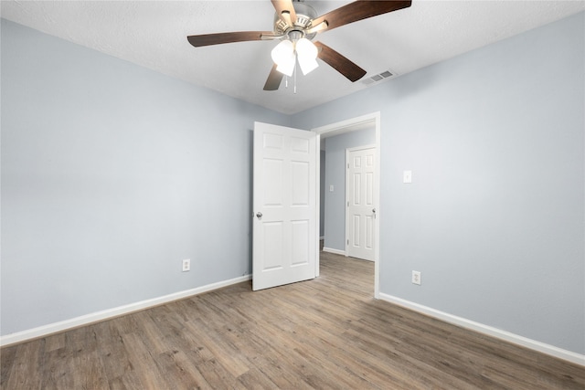 spare room featuring ceiling fan, wood-type flooring, and a textured ceiling