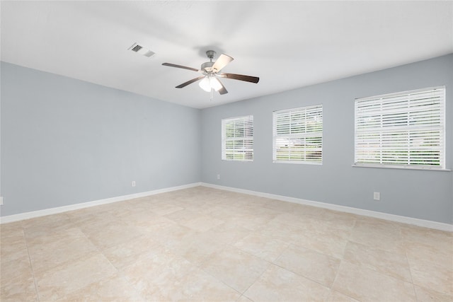 tiled spare room featuring ceiling fan