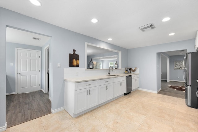 kitchen with sink, white cabinets, light hardwood / wood-style flooring, and appliances with stainless steel finishes