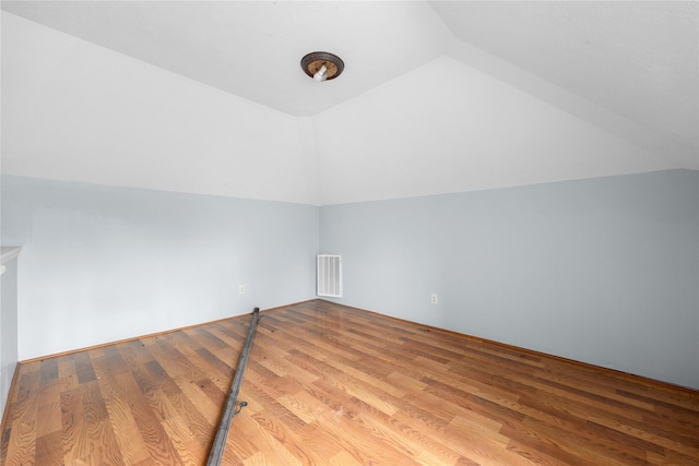 additional living space with light hardwood / wood-style flooring and lofted ceiling