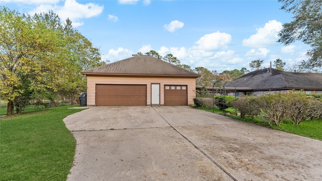 view of property exterior featuring a garage, a yard, and an outbuilding