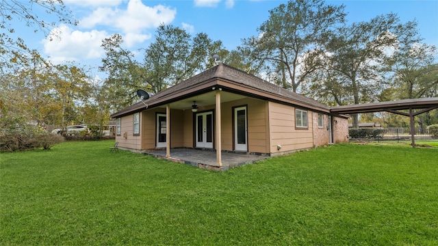 rear view of property with ceiling fan, a yard, and a patio