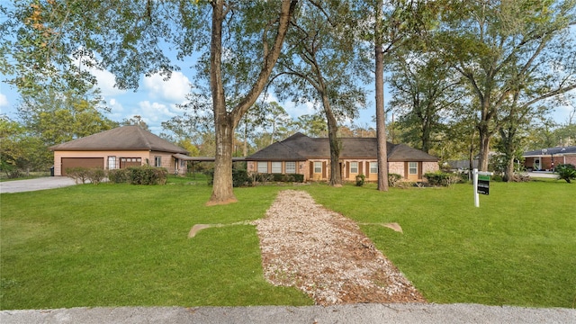 ranch-style home featuring a garage and a front lawn