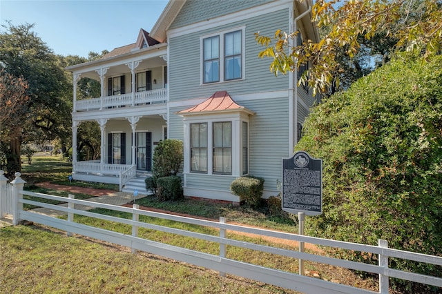 view of front of property with covered porch and a balcony