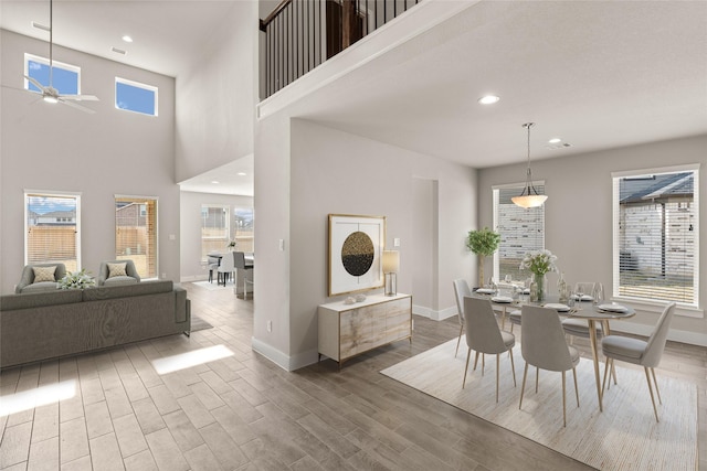 dining area featuring hardwood / wood-style floors, a wealth of natural light, and a high ceiling