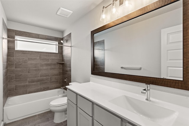 full bathroom with hardwood / wood-style floors, vanity, toilet, and tiled shower / bath