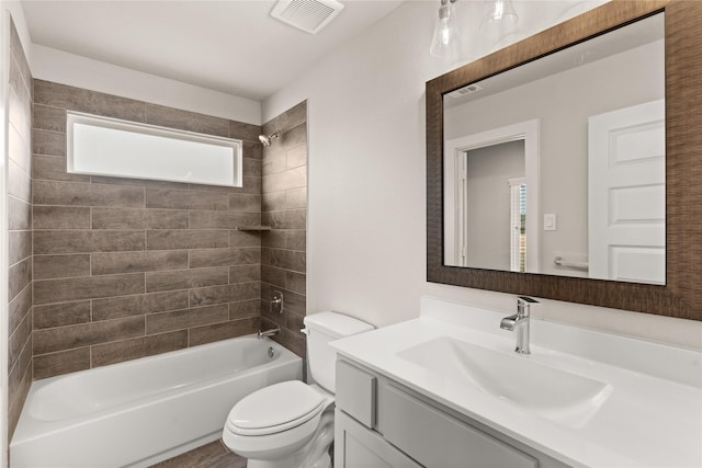 full bathroom with vanity, a healthy amount of sunlight, tiled shower / bath combo, and toilet