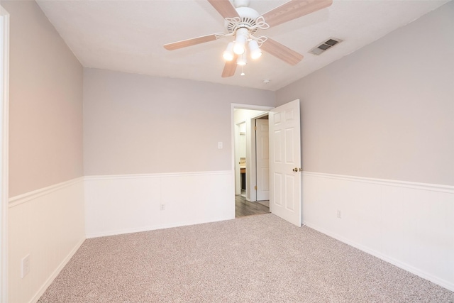 carpeted spare room with ceiling fan