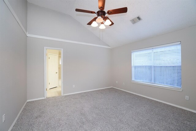 spare room with lofted ceiling, a textured ceiling, light colored carpet, and ceiling fan