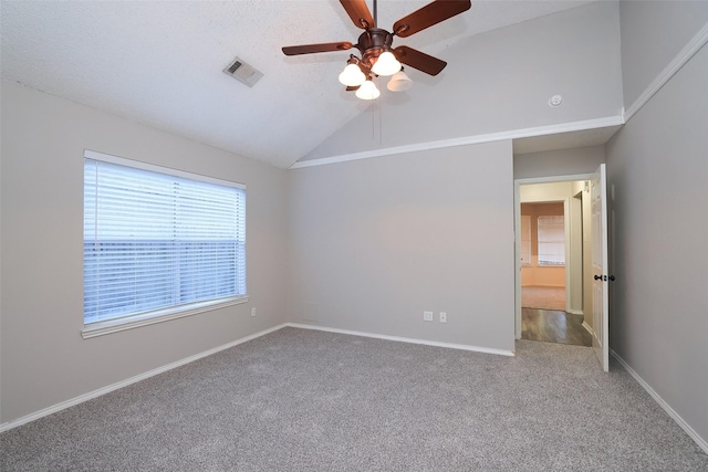 carpeted empty room with lofted ceiling, a textured ceiling, and ceiling fan