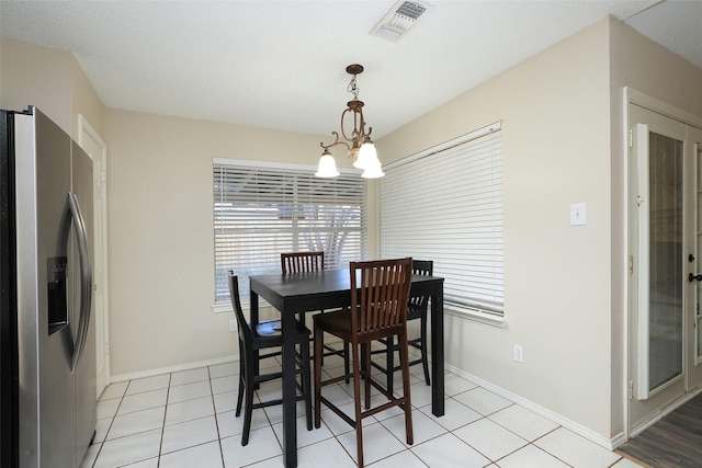 dining room with light tile patterned floors and a chandelier