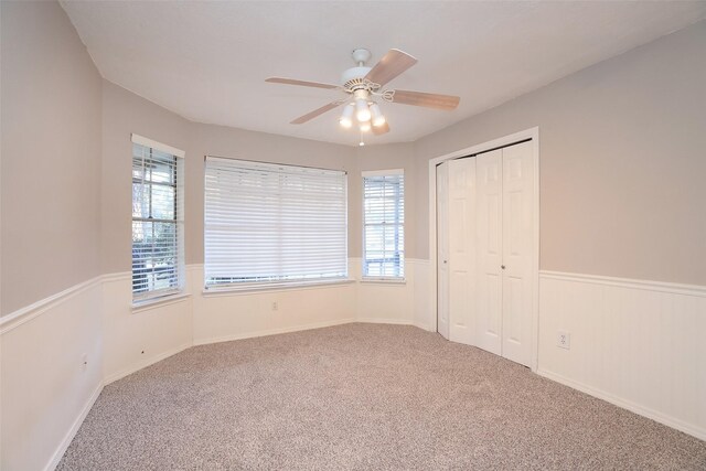 unfurnished bedroom with carpet flooring, ceiling fan, and a closet