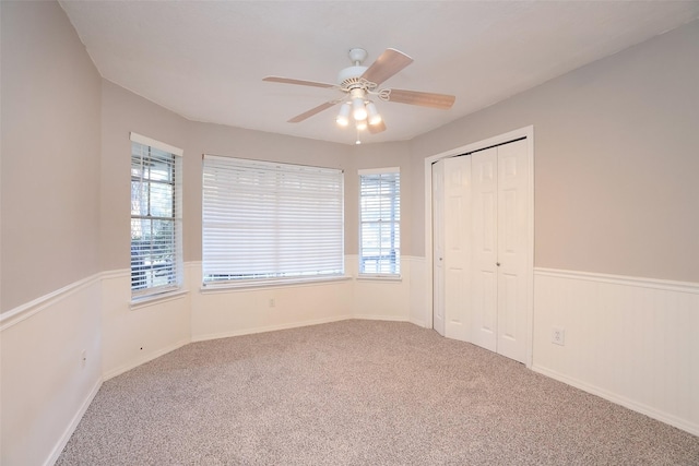 unfurnished bedroom with carpet, ceiling fan, and a closet