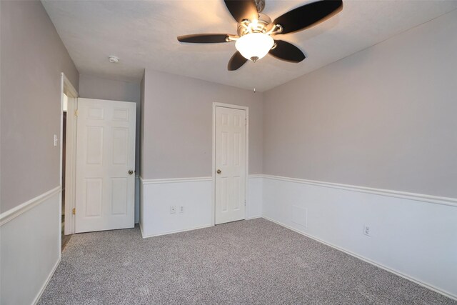 unfurnished bedroom featuring carpet floors, ceiling fan, and a closet