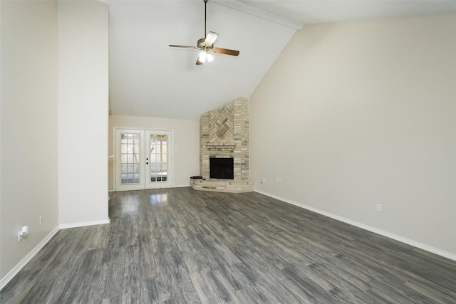 unfurnished living room featuring ceiling fan, high vaulted ceiling, dark hardwood / wood-style flooring, a brick fireplace, and french doors