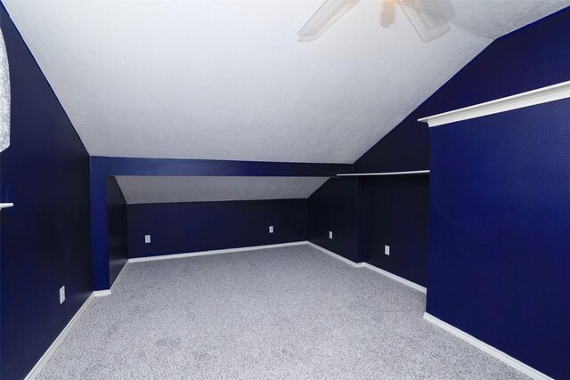 bonus room with ceiling fan, carpet flooring, vaulted ceiling, and a textured ceiling