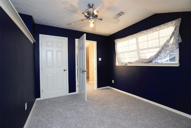 unfurnished bedroom featuring vaulted ceiling, ceiling fan, and carpet flooring